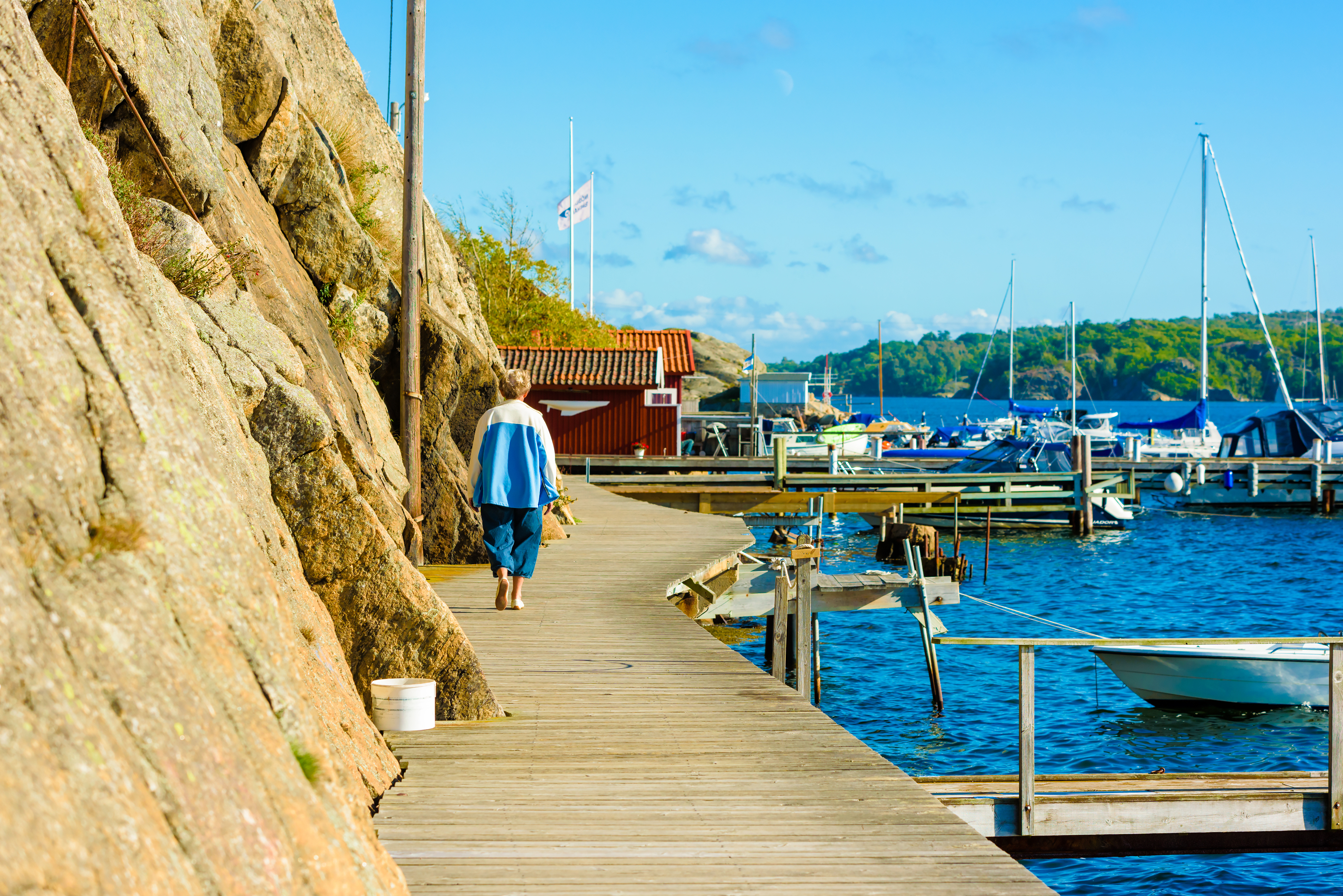 Kvinna går på brygga längs havet